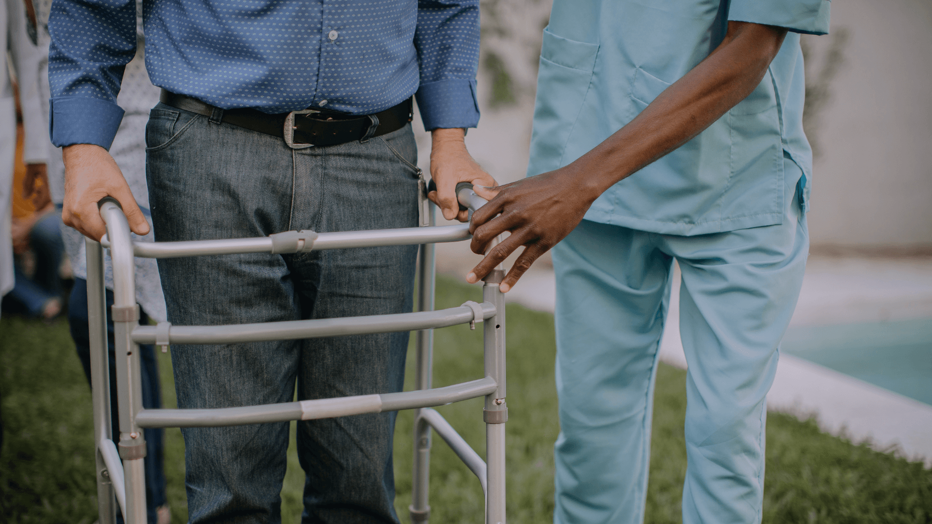 Man met rollator en zorgmedewerker ondersteunt