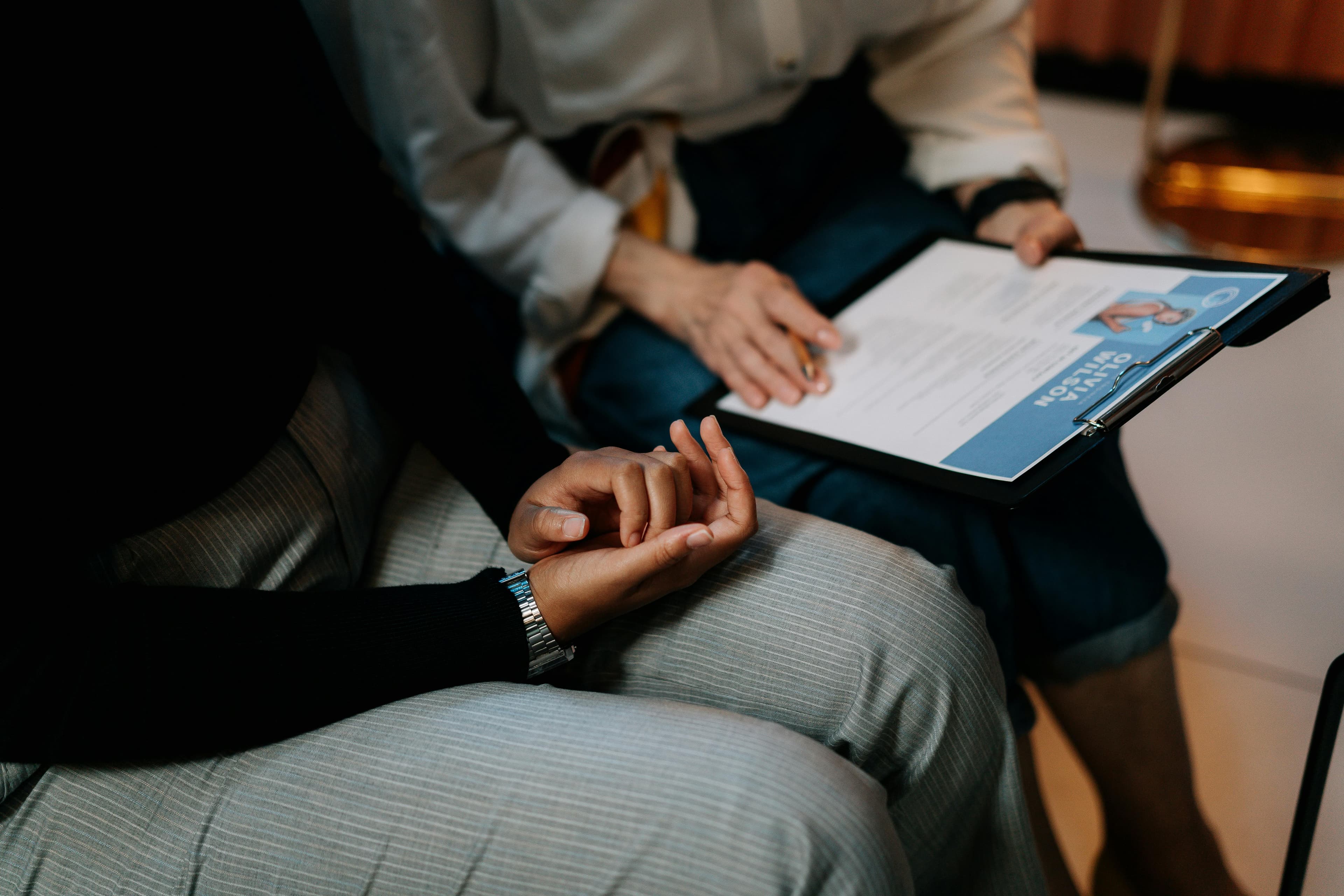 twee personen die een CV bespreken handen op de schoot