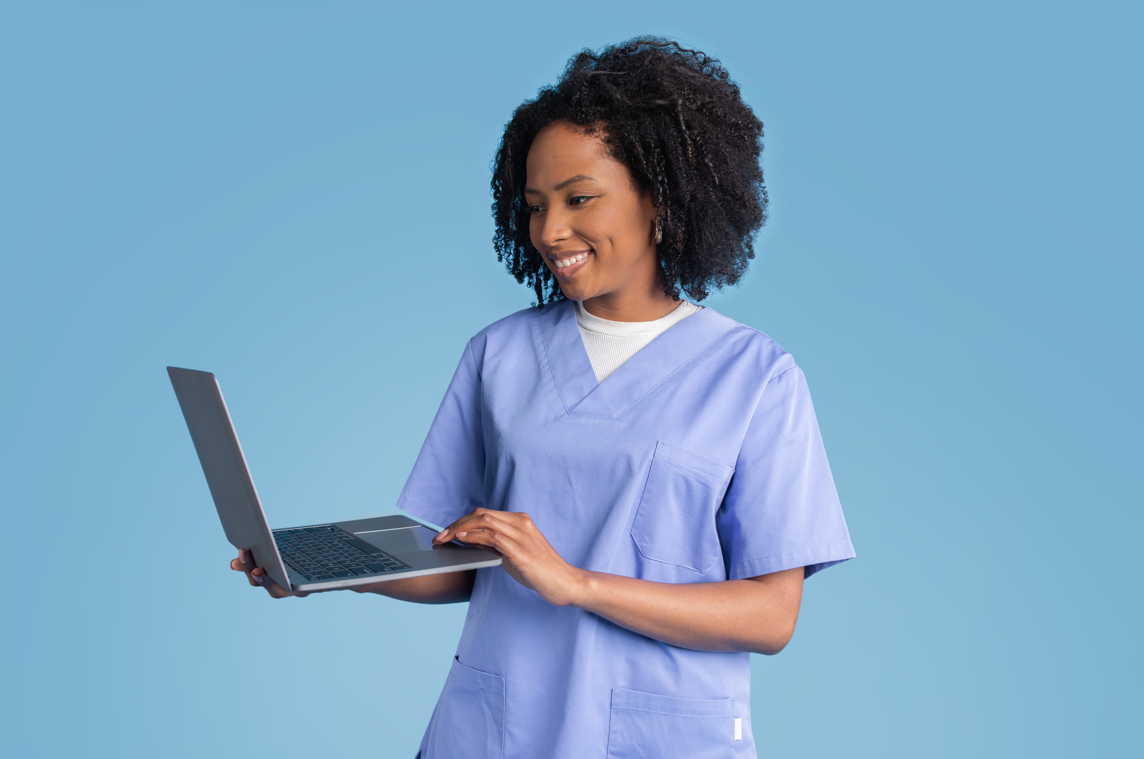 Vrouweljke zorgmedewerker met een laptop in haar handen