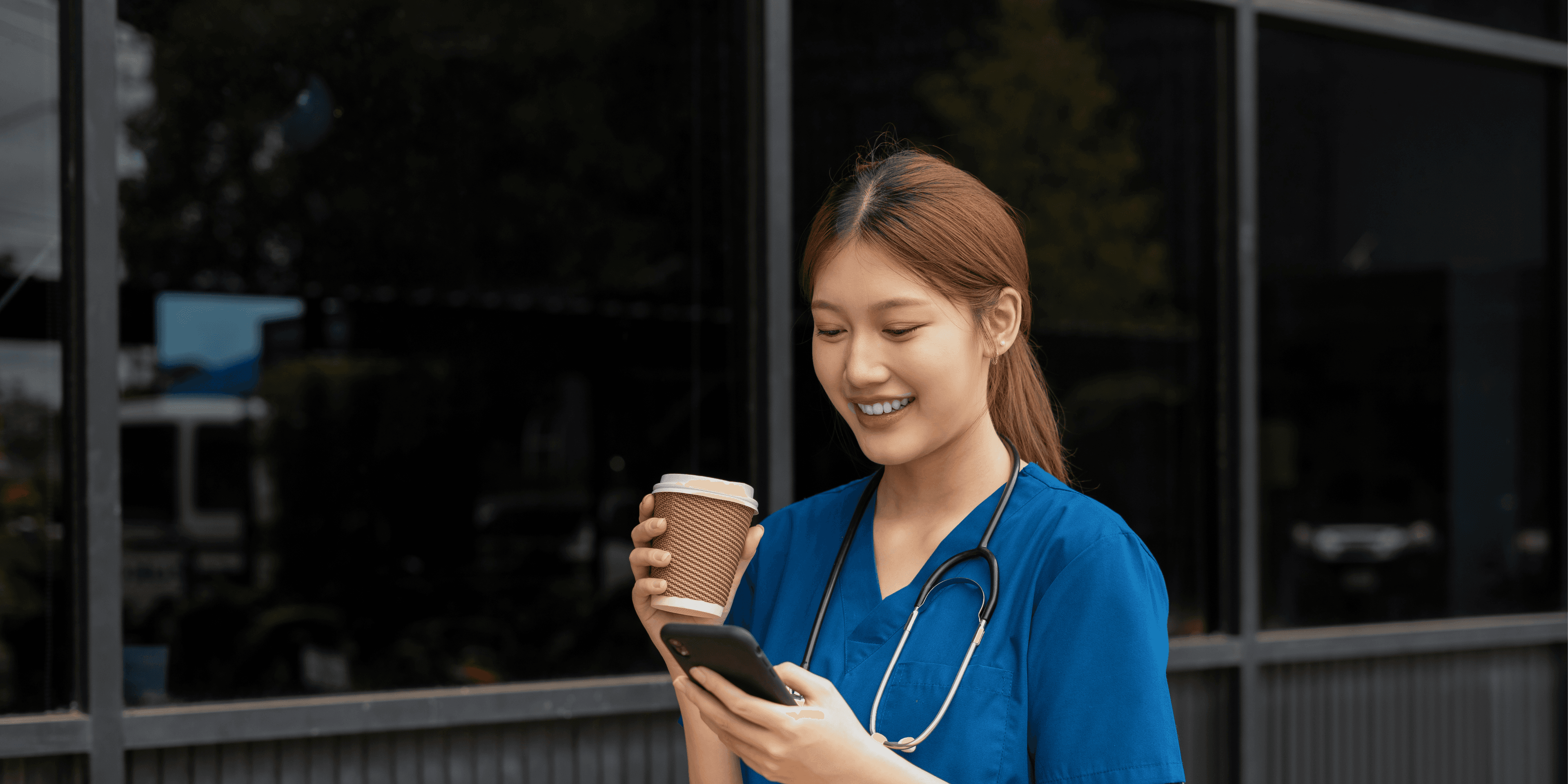 Ziekenhuismedewerker met pauze drinkt koffie en zit op haar telefoon tjdens wandeling