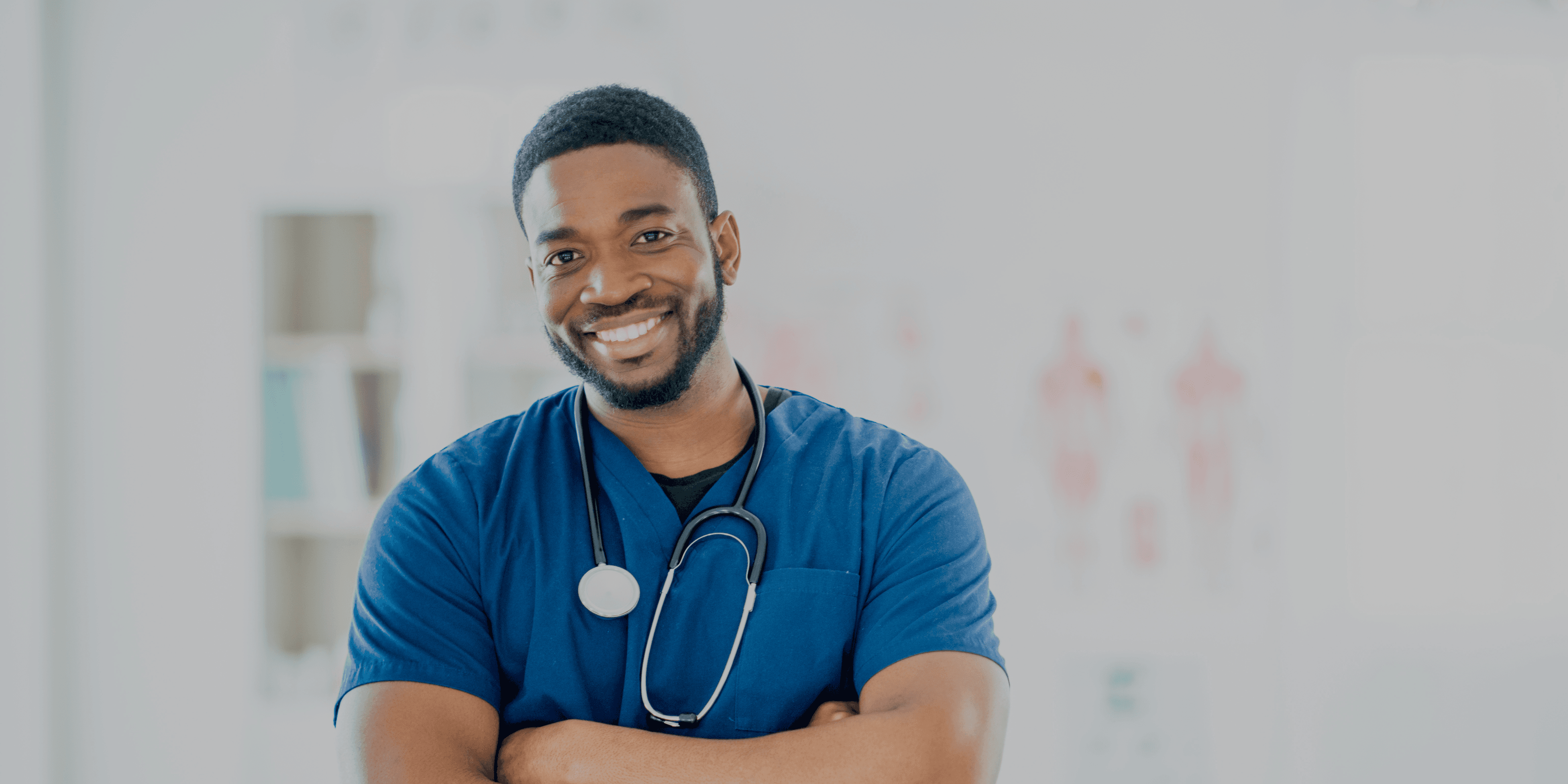 Tevreden-man-met-stethoscoop-om-zijn-nek-en-armen-over-elkaar-in-het-ziekenhuis