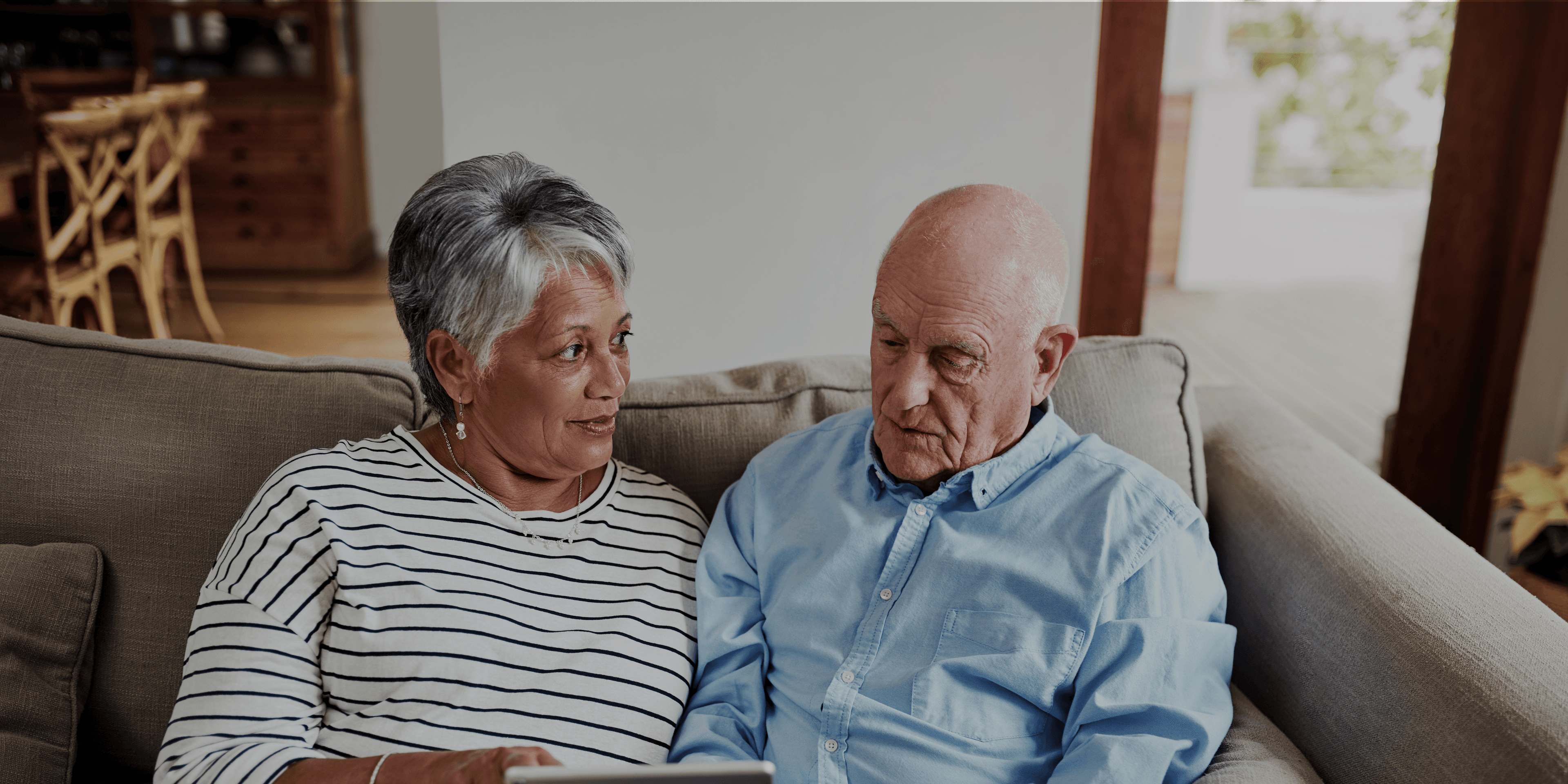 Ouder echtpaar op de bank in gesprek met elkaar