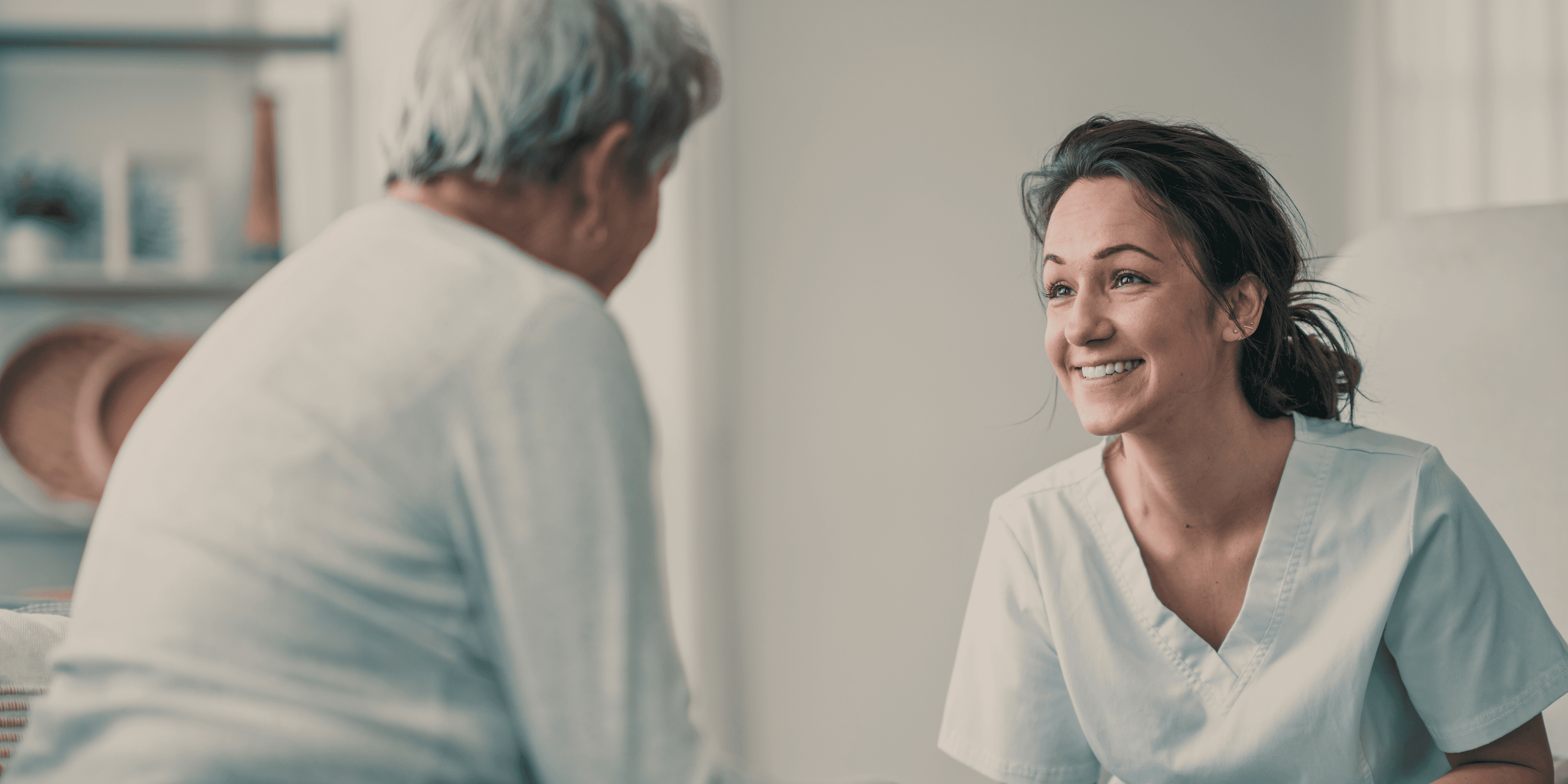 Oudere mevrouw met helpende in gesprek bij mevrouw thuis