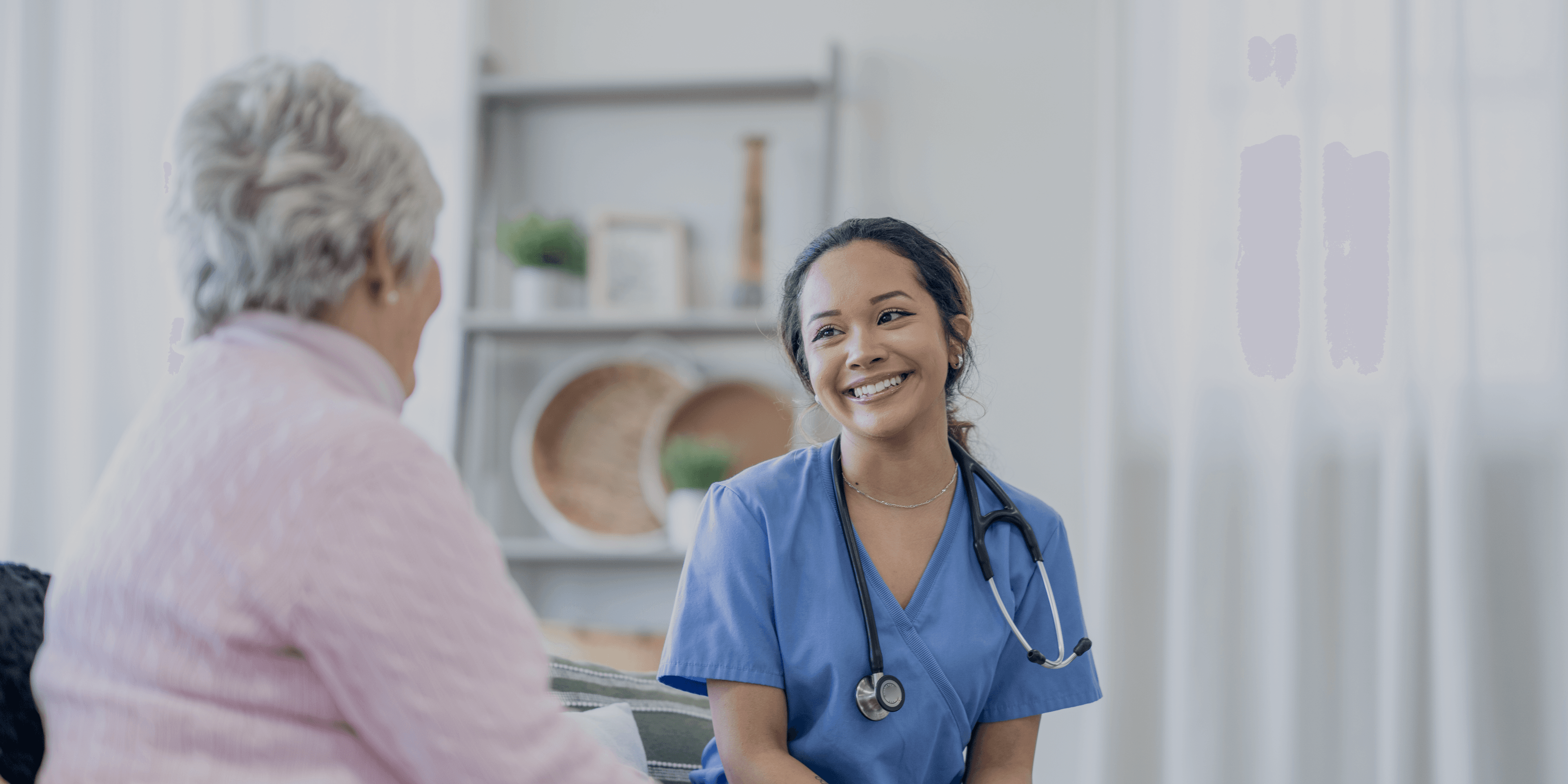 Verzorgende IG in gesprek met cliënt in huis